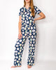 Woman wearing a navy blue pajama set with colorful geometric patterns on a white background