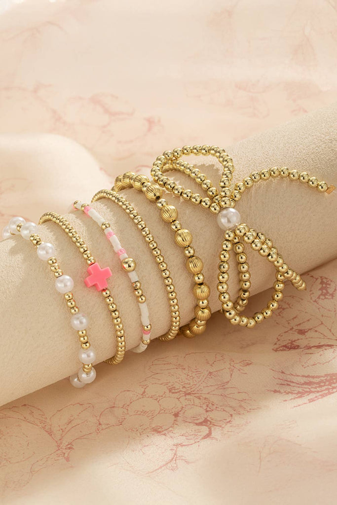 set of gold and pearl bow bracelets
