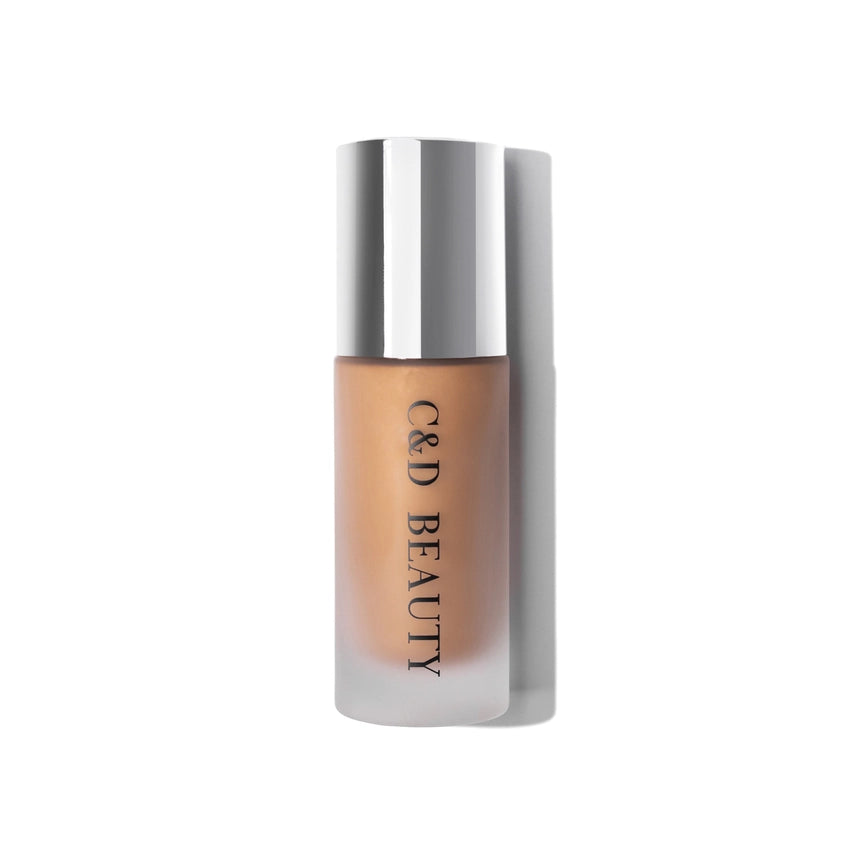 Foundation bottle with silver cap and beige shade on a white background