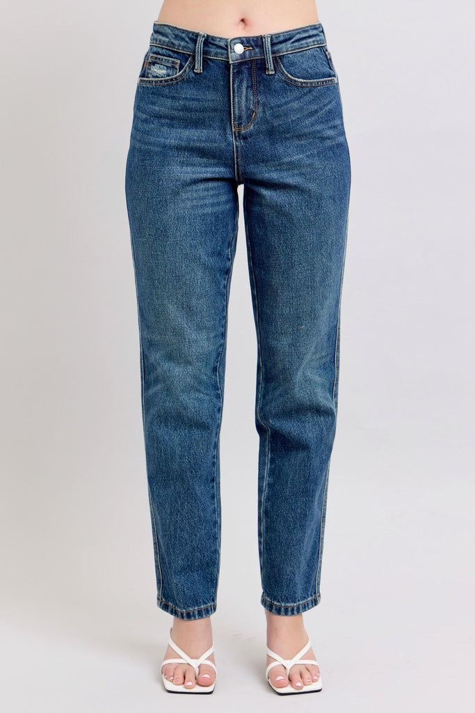 Blue jeans worn by a person on a plain background