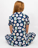 Person wearing a navy blue dress with colorful geometric pattern on a white background