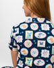 Woman wearing a navy blue shirt with colorful dog pattern on a white background