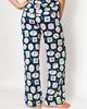Navy blue pajama pants with colorful dog pattern on a white background