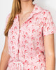 Person wearing a pink pajama set with Santa Claus pattern on a white background