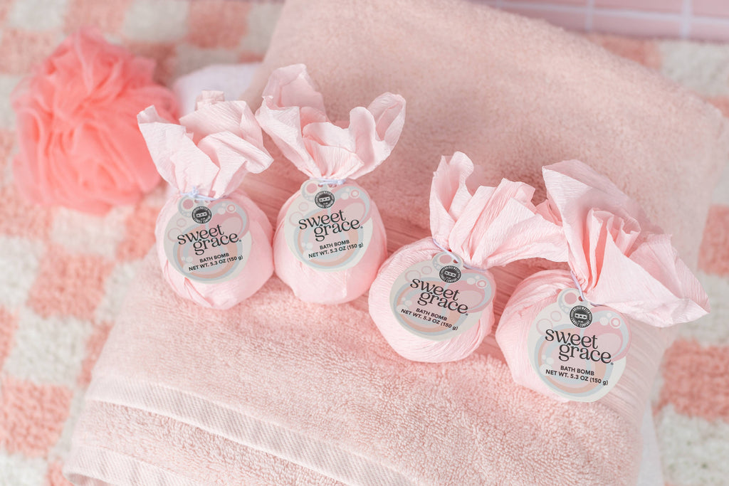 Four small containers labeled 'sweet grace' on a pink checkered background