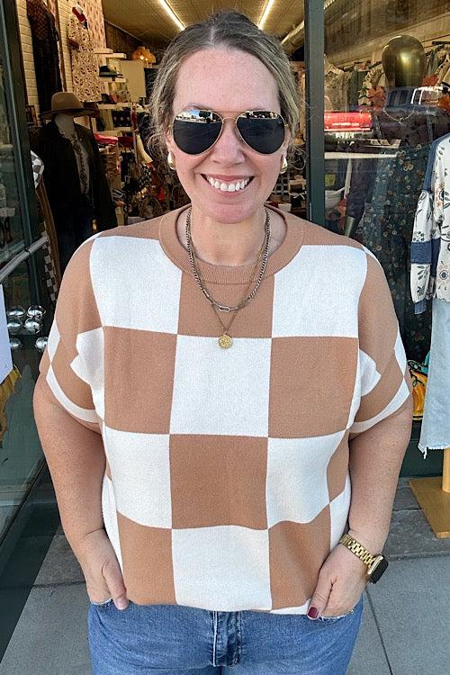 Woman wearing a checkered top and sunglasses in a store setting