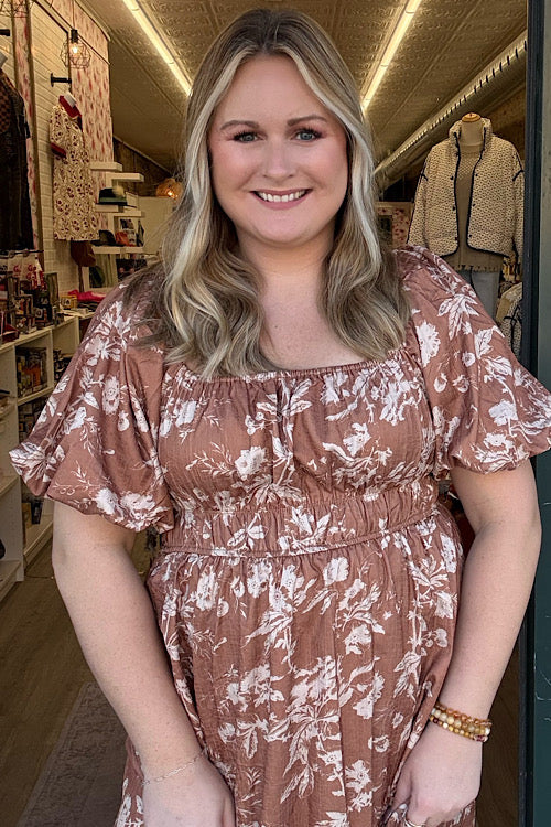 Woman wearing a floral dress in a store setting