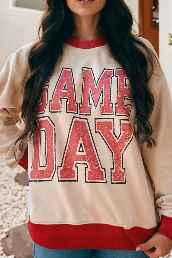 Person wearing a 'GAME DAY' sweatshirt with red and beige colors.