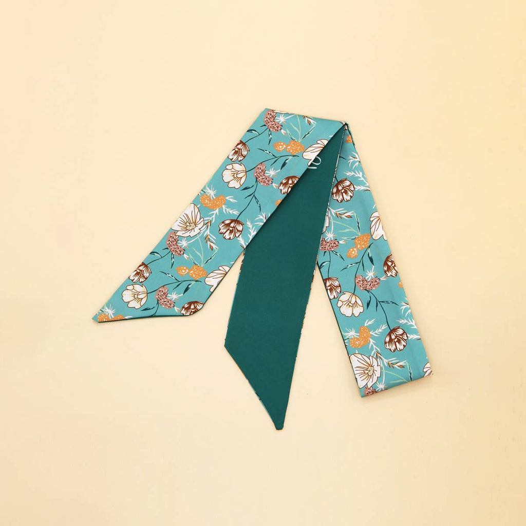 Teal and floral-patterned scarf on a beige background