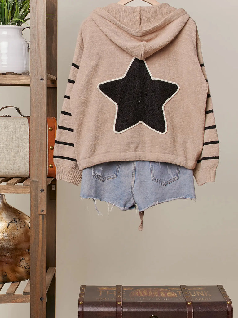 Taupe knit button-up hoodie with black star appliqués, striped sleeves, and drawstring hem, styled with a relaxed fit for casual boutique fashion.