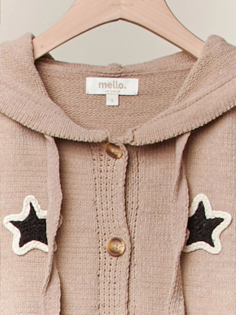 Taupe knit button-up hoodie with black star appliqués, striped sleeves, and drawstring hem, styled with a relaxed fit for casual boutique fashion.