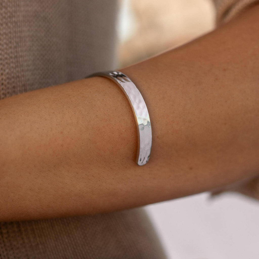 Silver bracelet on a wrist with a blurred background