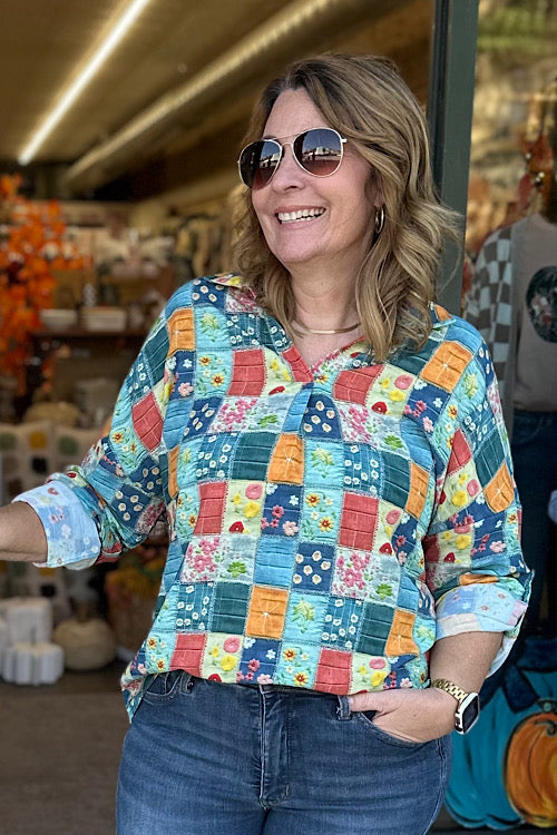 Person wearing a patchwork quilt jacket with floral and geometric patterns.