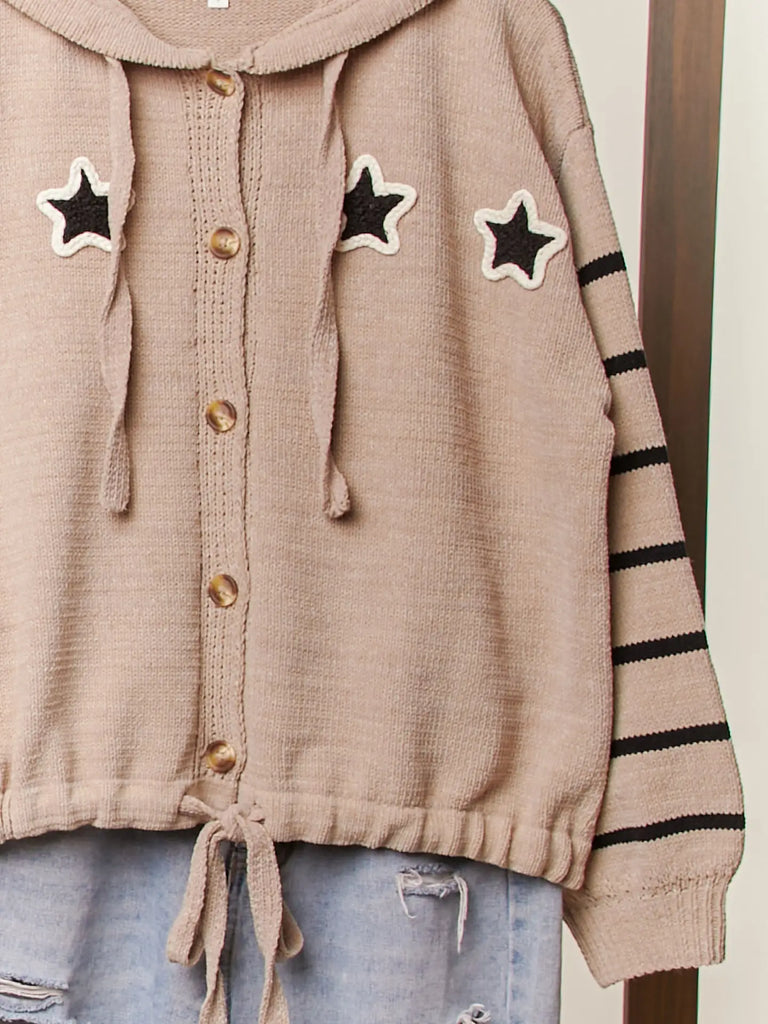 Taupe knit button-up hoodie with black star appliqués, striped sleeves, and drawstring hem, styled with a relaxed fit for casual boutique fashion.