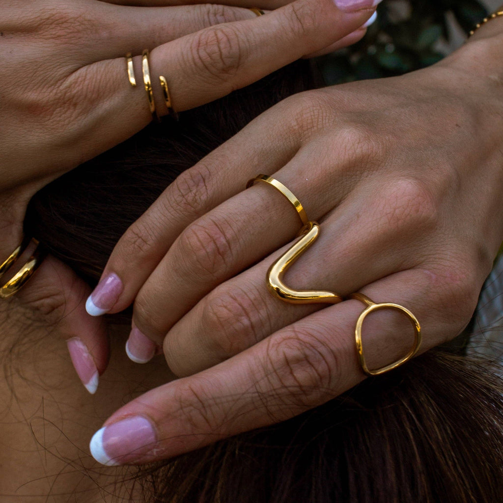 closeup of fingers with several gold rings