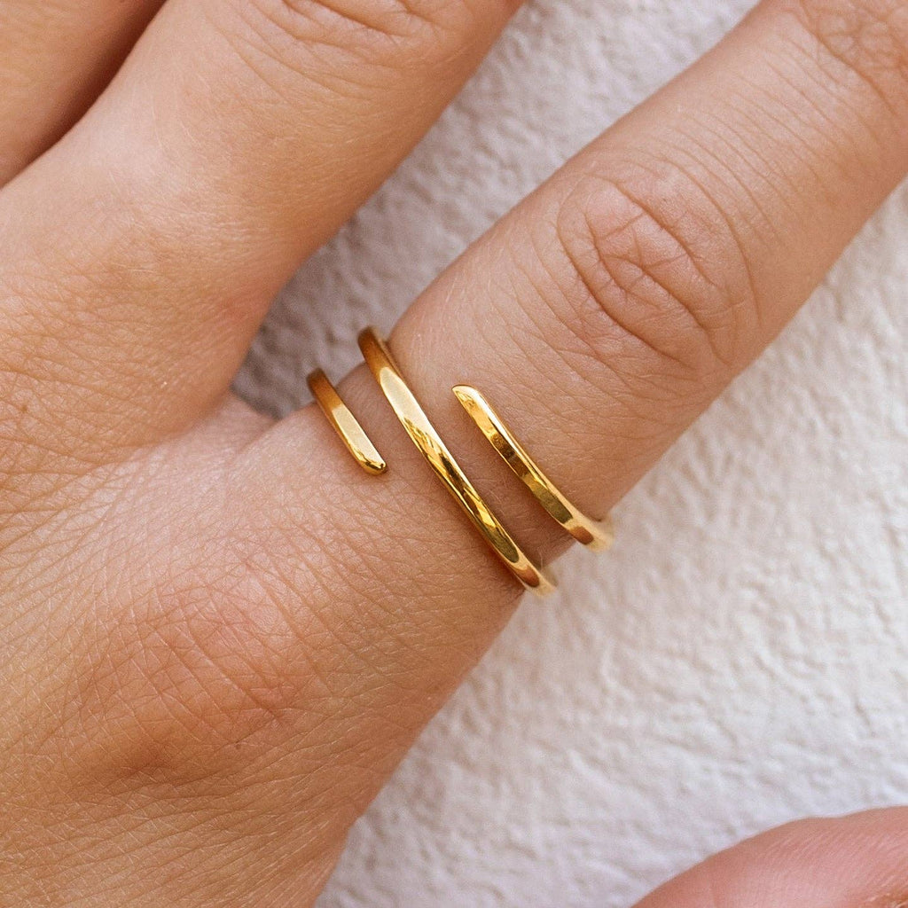 Gold ring on a finger against a white background