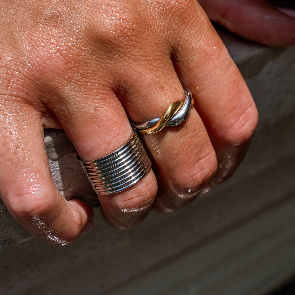Close-up of a hand with silver rings on a dark background