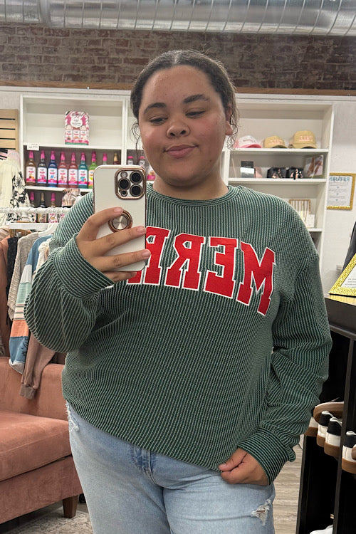 Person wearing a green sweater with red text in a store setting