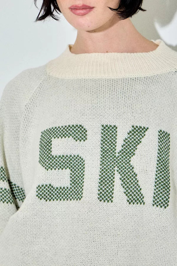 Araminta cream and green 'Ski' raglan sweater, with green text and stripes, a relaxed fit, and a ribbed crewneck.