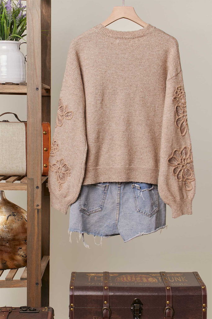 Taupe knit sweater with tonal embroidered floral designs and relaxed fit.