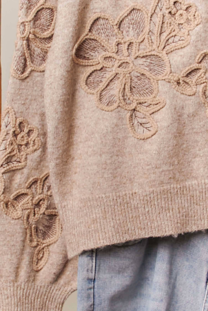 Taupe knit sweater with tonal embroidered floral designs and relaxed fit.