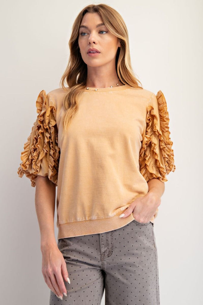 A honey latte-colored, mineral-washed short-sleeve top. It has a crew neck and dramatic, multi-layered ruffled sleeves.