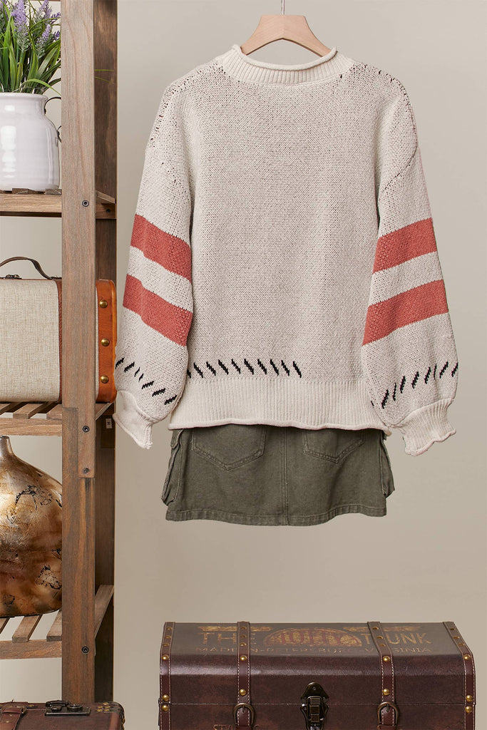Cream knit sweater with a large tiger face graphic and rust stripe sleeves.