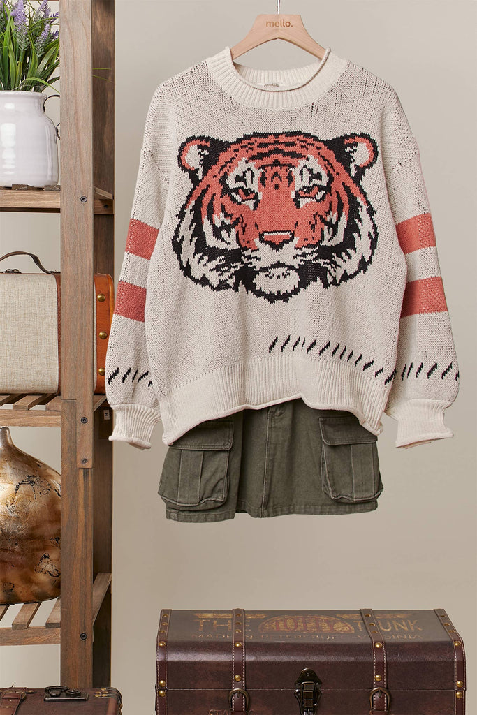 Cream knit sweater with a large tiger face graphic and rust stripe sleeves.