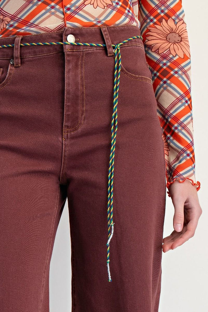 Clementina vintage wine wide-leg jeans with a high-waisted fit and frayed hem, styled with a patterned top and sneakers.