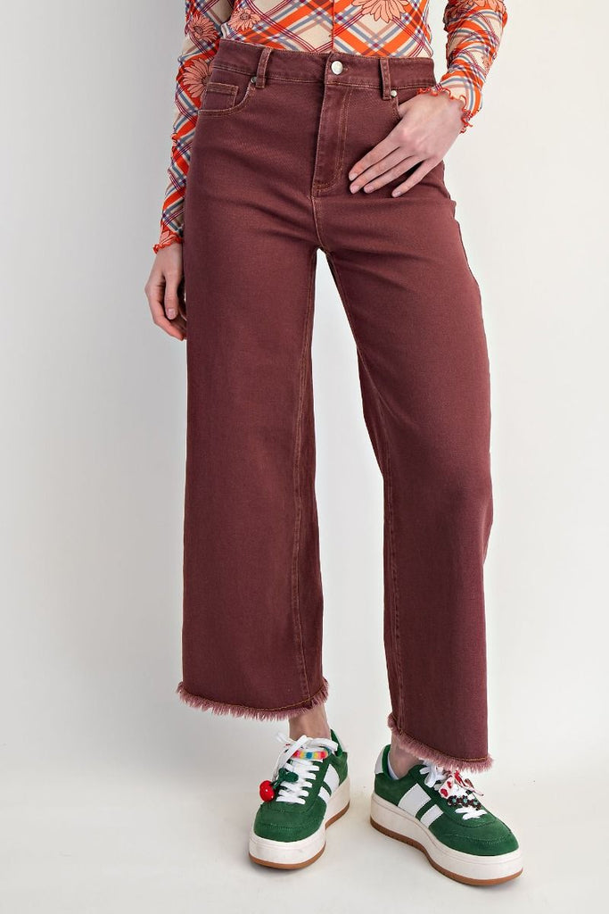 Clementina vintage wine wide-leg jeans with a high-waisted fit and frayed hem, styled with a patterned top and sneakers.
