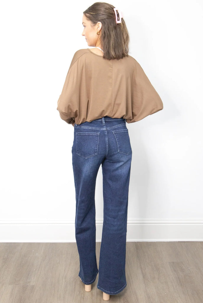 A high-waisted, wide-leg pair of dark wash jeans with a frayed hem.