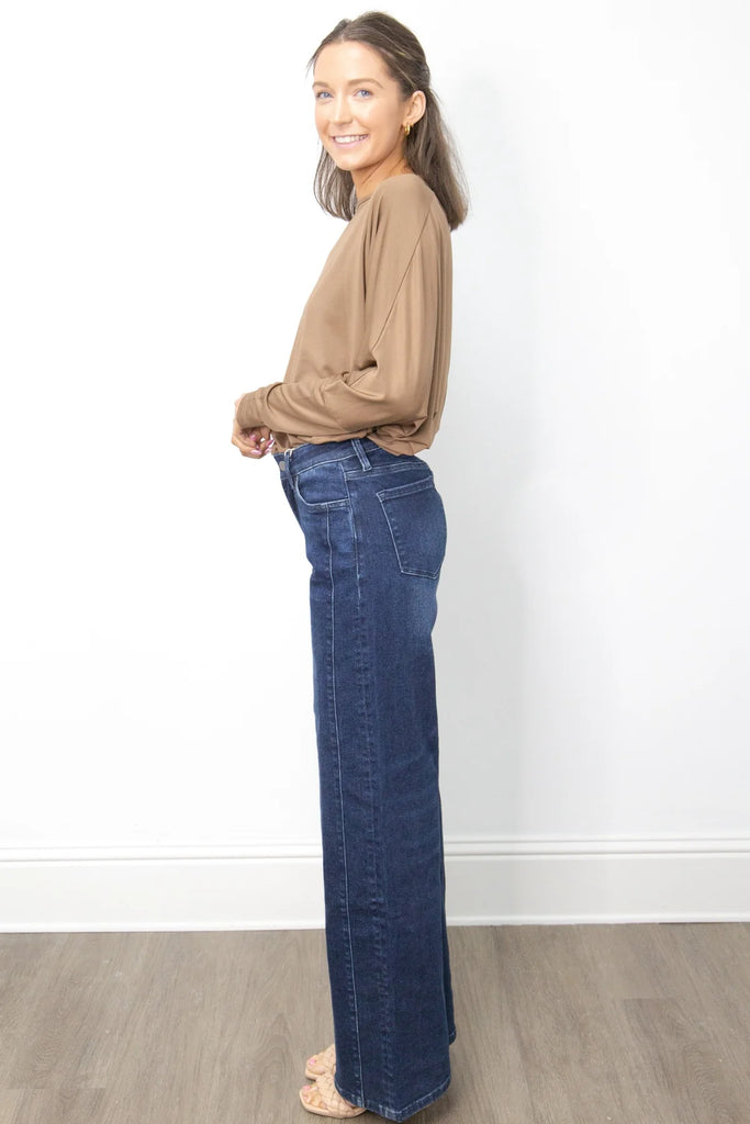 A high-waisted, wide-leg pair of dark wash jeans with a frayed hem.