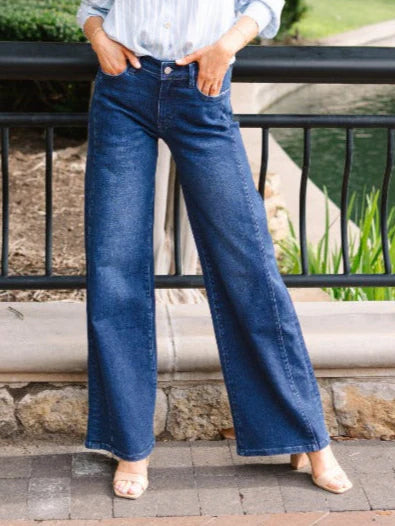A high-waisted, wide-leg pair of dark wash jeans with a frayed hem.