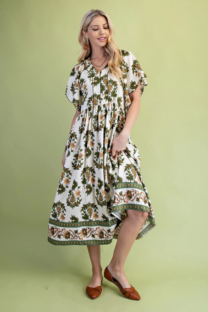 Midi dress with olive and golden floral print, V-neckline, scalloped short sleeves, covered buttons, and flowing skirt with border trim