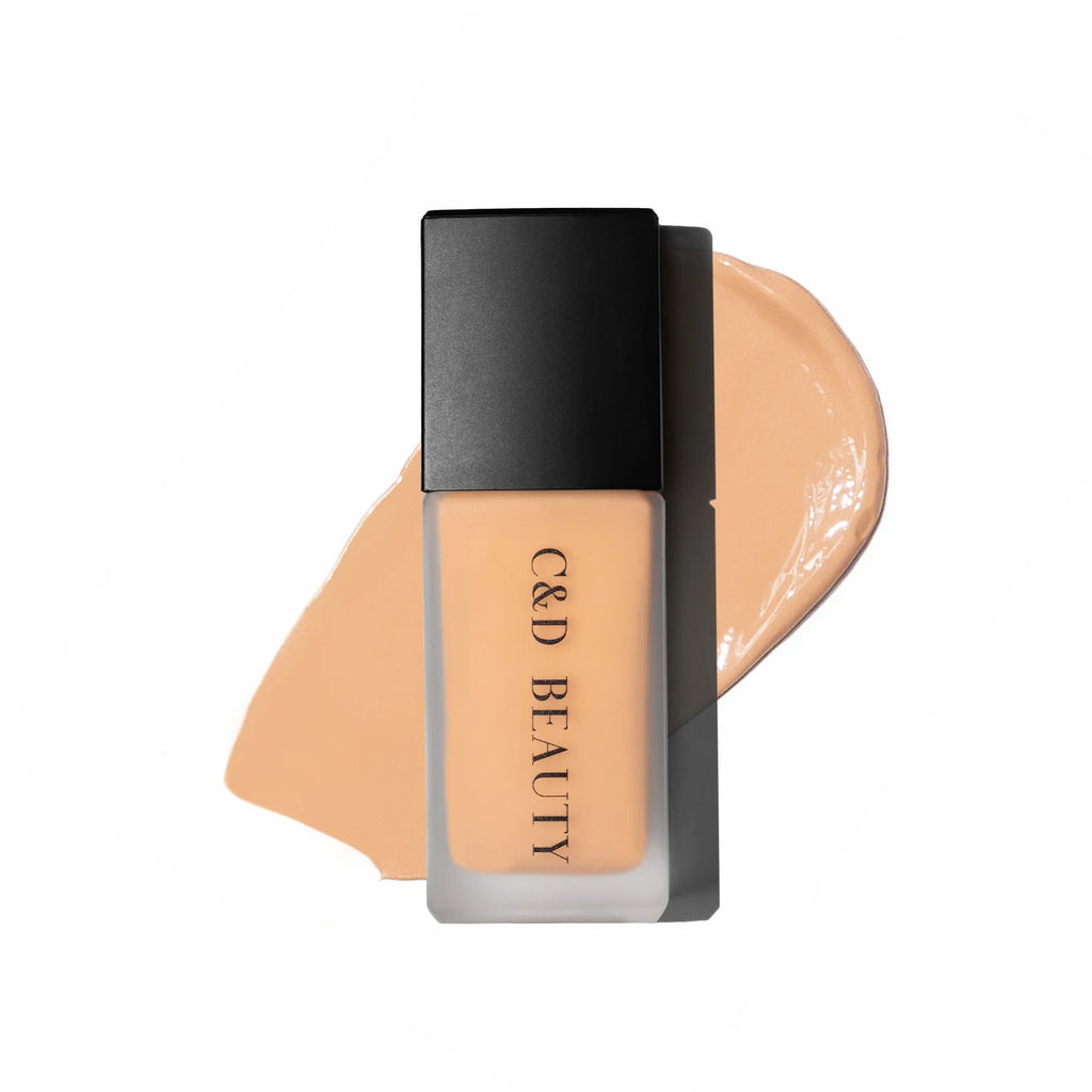 Foundation bottle with a swatch of beige color on a white background