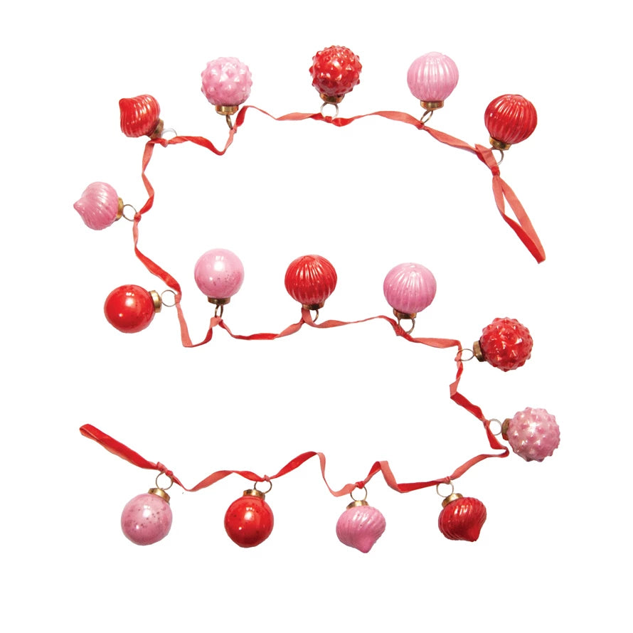 Vintage-inspired mercury glass ornament garland with red and pink embossed glass ornaments, strung on a velvet ribbon. 72-inch length for mantel, tree, or table décor.