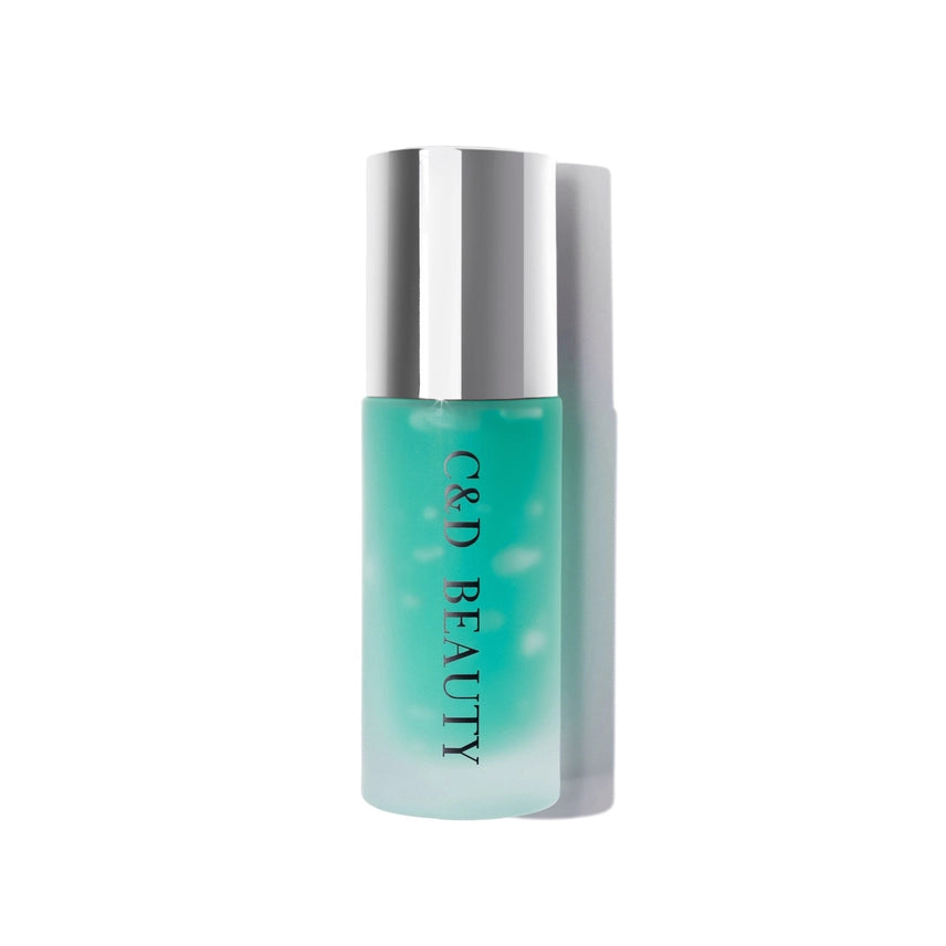 Skincare bottle with silver cap and teal body on a white background