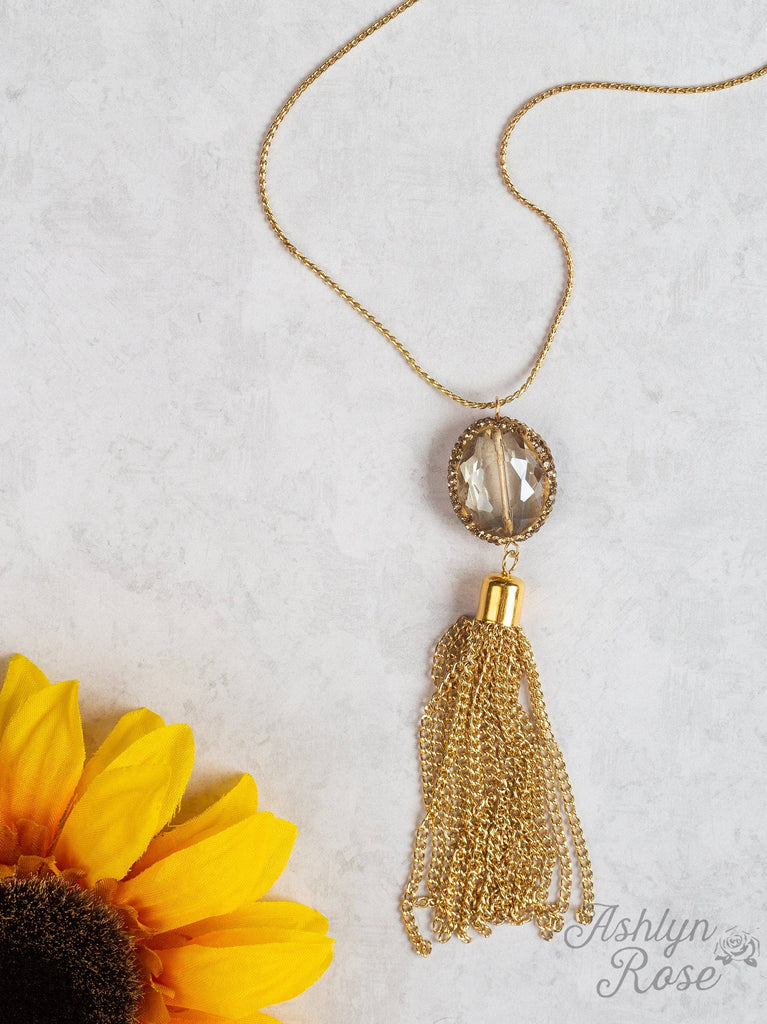  Gold chain necklace featuring a faceted gemstone pendant and cascading gold tassel accent.