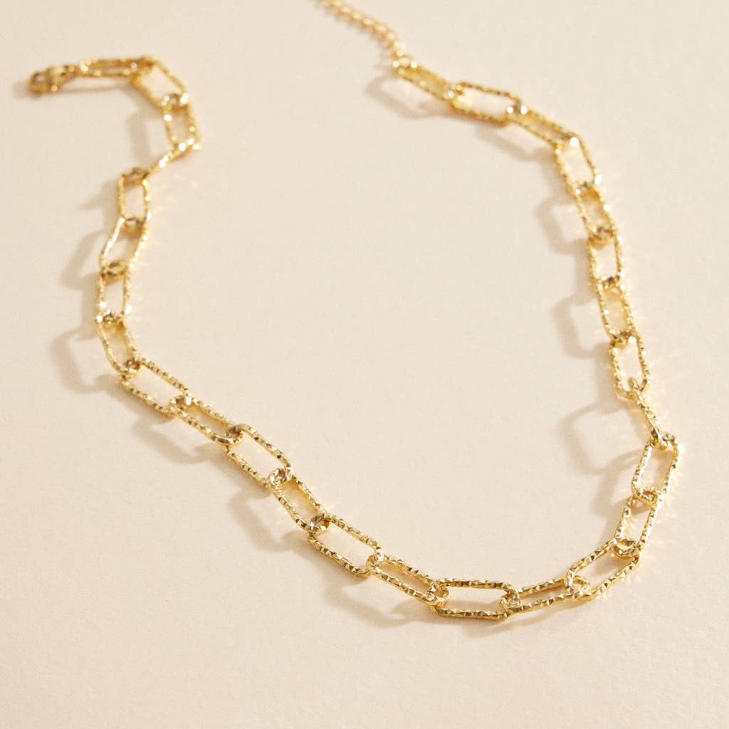 Gold chain linked short necklace with textured links.