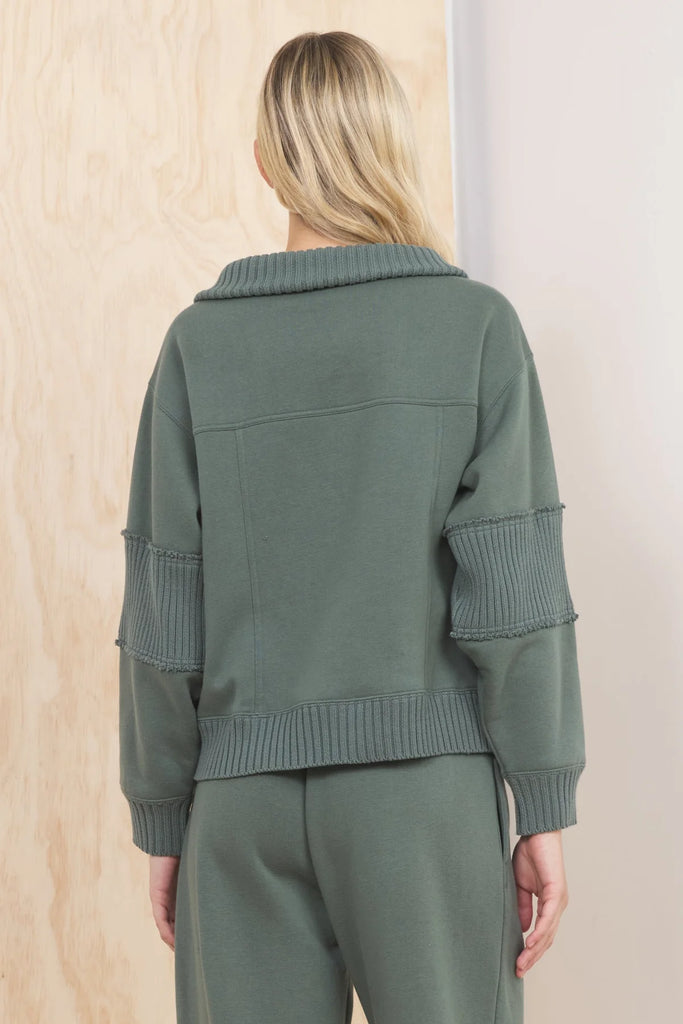An olive green fleece quarter-zip pullover with a wide, ribbed collar and ribbed panels on the sleeves. The pullover has a relaxed, cropped fit.