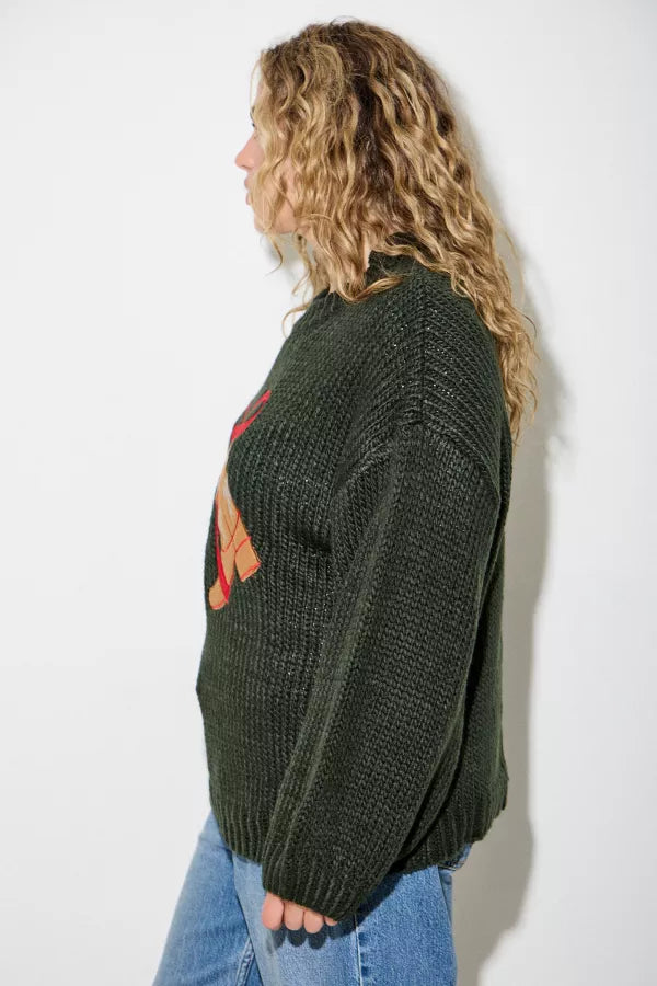Model wearing Hadley Western Boot Sweater by Polagram in deep forest green featuring embroidered boots with red bow detail.