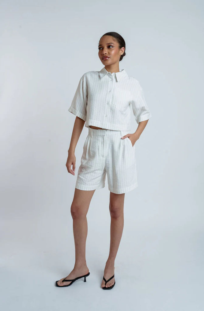 Woman wearing a white outfit with a plain background