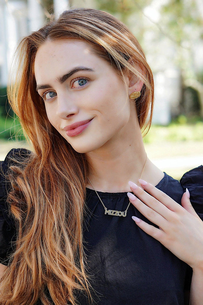 Woman with long blonde hair wearing a black top outdoors