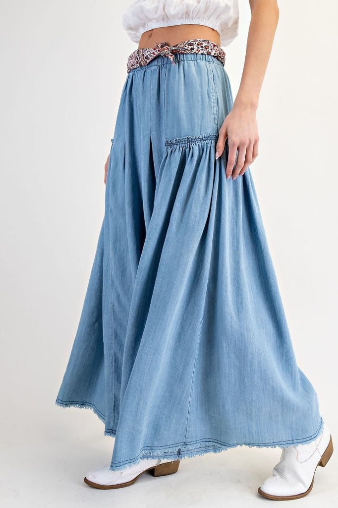 Light wash chambray tiered wide-leg pants with elastic paper-bag waist, patterned fabric tie belt, and flowing silhouette for a bohemian and comfortable style