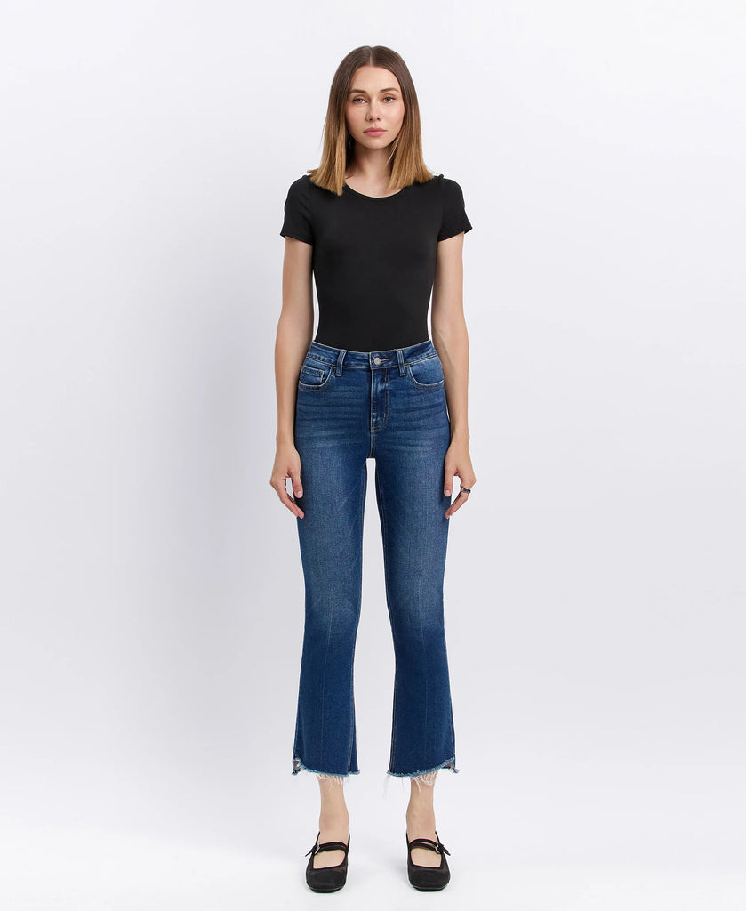 Lovervet cropped flare jeans in medium-dark wash with raw frayed hem, styled with a black fitted top and black ballet flats.