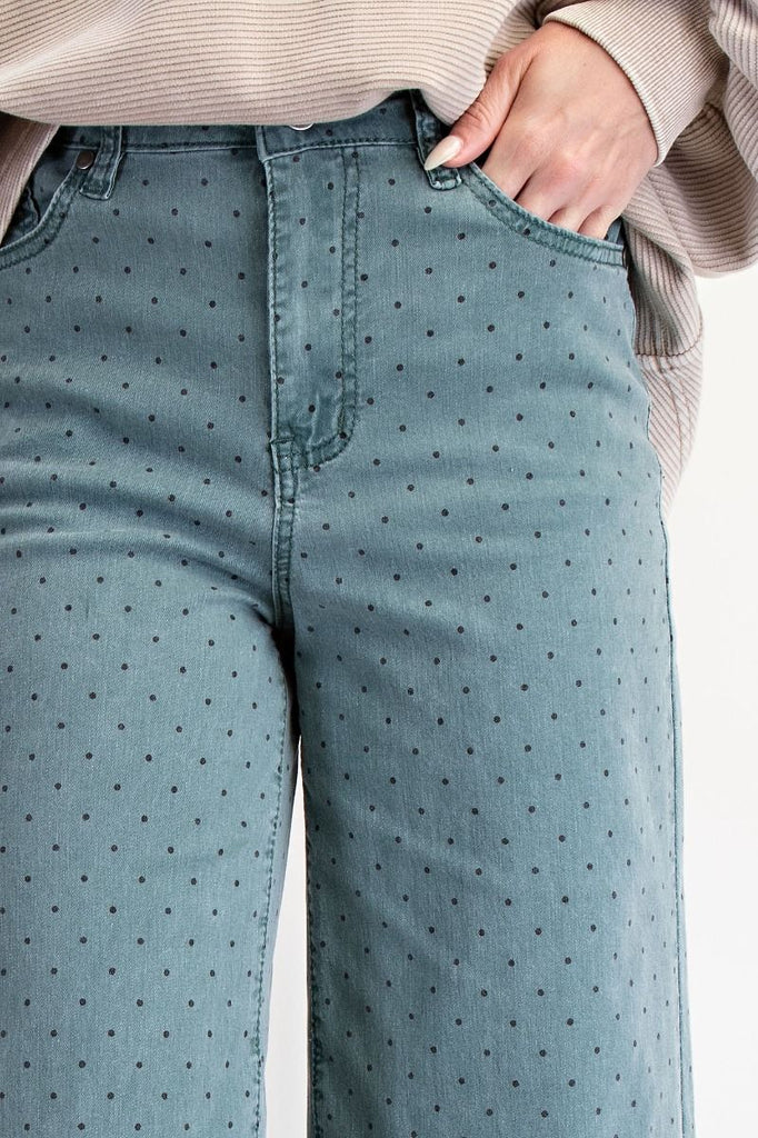 A pair of high-waisted, wide-leg, cropped pants in a teal green washed twill with a black polka dot print.