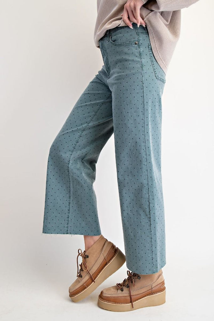 A pair of high-waisted, wide-leg, cropped pants in a teal green washed twill with a black polka dot print.