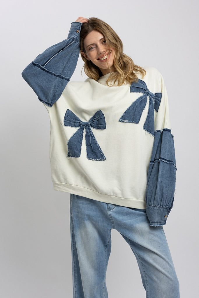 Marceline Denim Bow Contrast Sweatshirt featuring oversized fit, frayed denim bows, and soft mineral-washed French terry fabric.