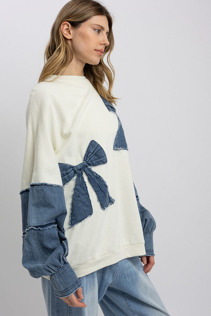 Marceline Denim Bow Contrast Sweatshirt featuring oversized fit, frayed denim bows, and soft mineral-washed French terry fabric.