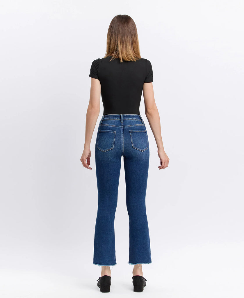 Lovervet cropped flare jeans in medium-dark wash with raw frayed hem, styled with a black fitted top and black ballet flats.
